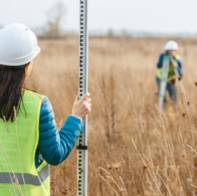 Selective focus of surveyors with survey ruler and digital level in field